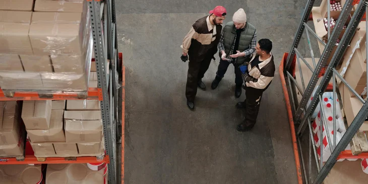 A factory manager training two new factory workers and about to show them around the factory.