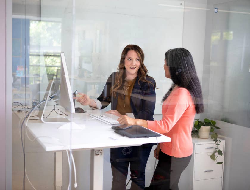 A Female Field Operations Manager in an office setting discussing with a colleague.