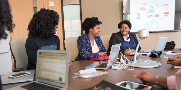 Female financial consultant sitting inside the conference room having a meeting with her clients