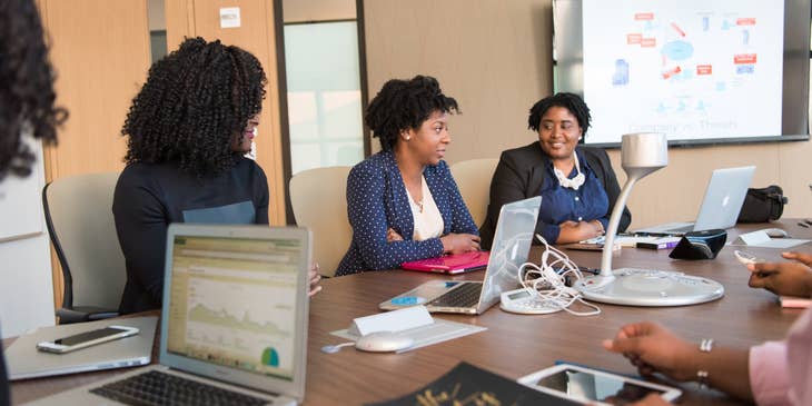 female Financial Consultant sitting inside the conference room having a meeting with her clients