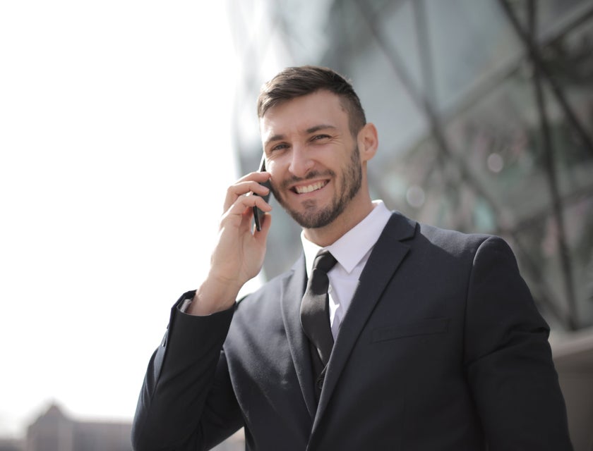 Financial Officer wearing a black business suit while holding a mobile phone