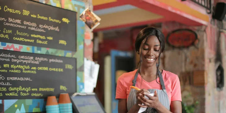 A food server ensuring accuracy of order before entering it into the system.