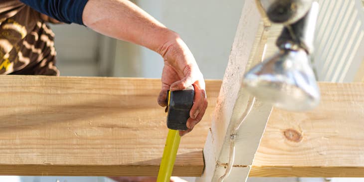 Framing Carpenter is making sure that the measurement is accurate.