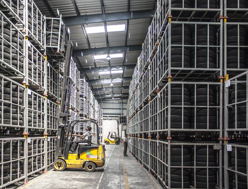 A Freight Handler using a forklift in a warehouse handling and stacking up materials collected.