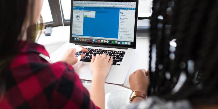 two Full Stack Developers working on the chat interface of a mobile application and sharing a workstation