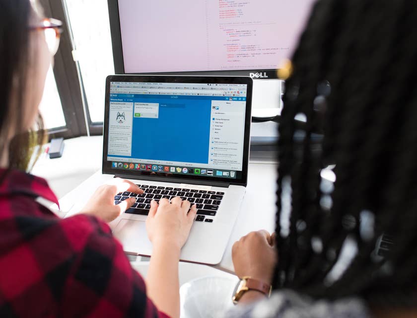 two Full Stack Developers working on the chat interface of a mobile application and sharing a workstation