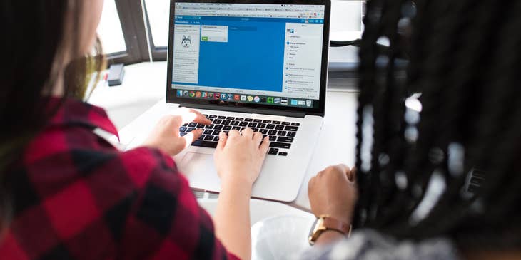 two Full Stack Developers working on the chat interface of a mobile application and sharing a workstation