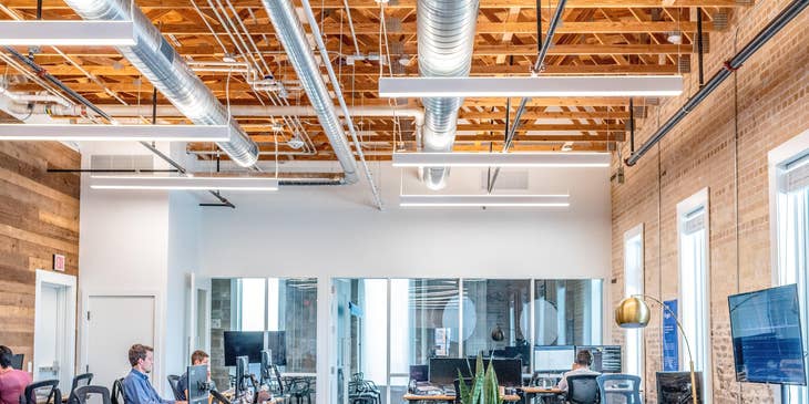 a team of Full Stack Engineers working on their respective workstations with the interior of the office being shown as well