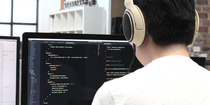 a Game Developer checking his code for some errors while listening to music