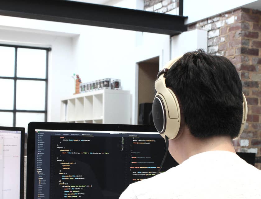 a Game Developer checking his code for some errors while listening to music