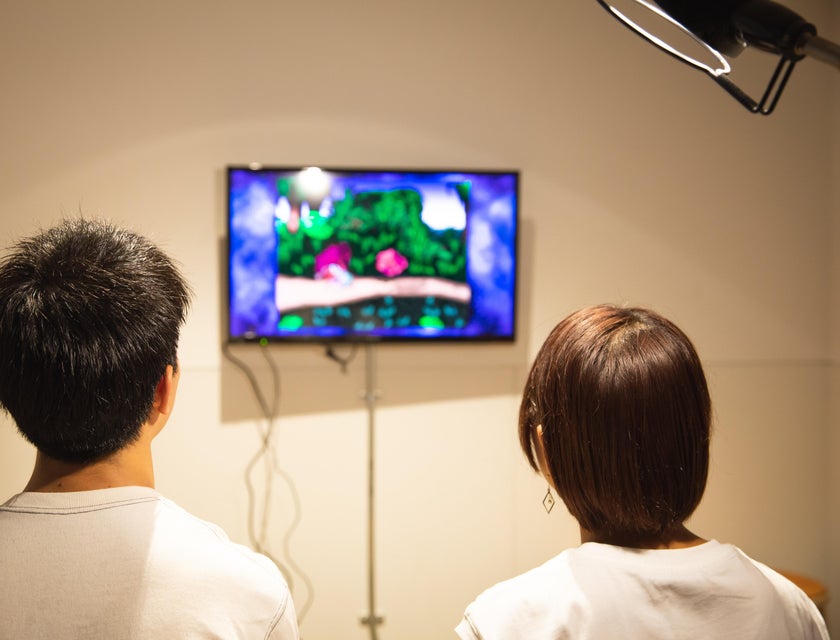 two Game Programmers testing a product prototype on the wall-mounted television
