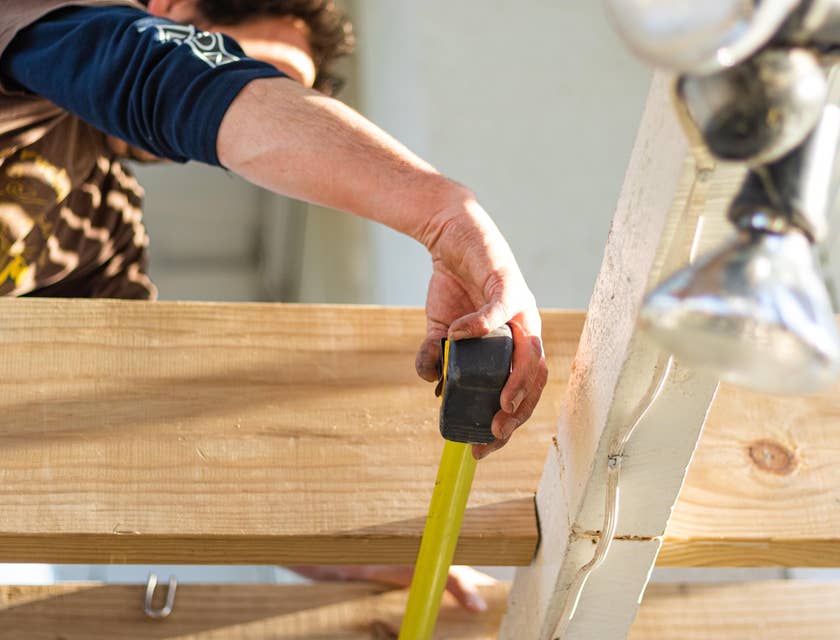 General Laborer measuring wooden boards