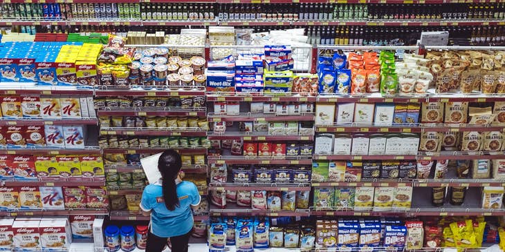 Grocery clerk checking for products that needs to be replaced.