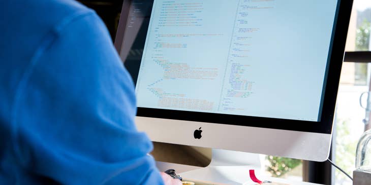 Hadoop developer working on an application while sitting at his workstation