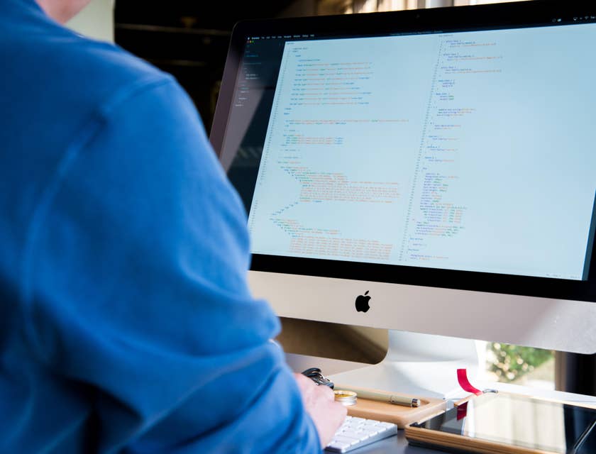 Hadoop developer working on an application while sitting at his workstation