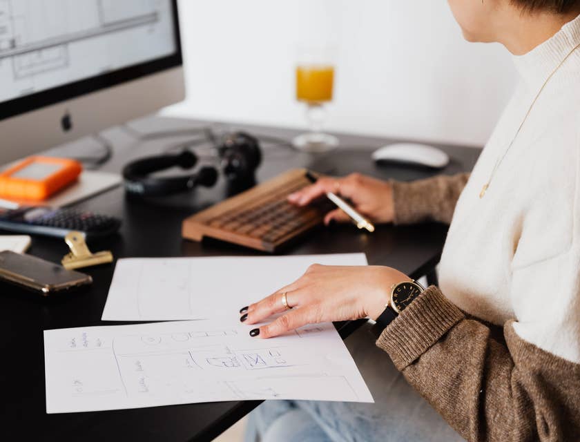 Head of Finance holding white papers while sitting in front of her desktop