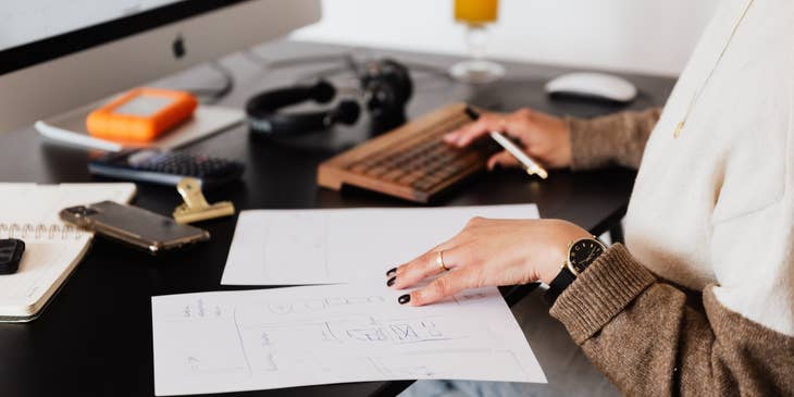 Head of Finance holding white papers while sitting in front of her desktop