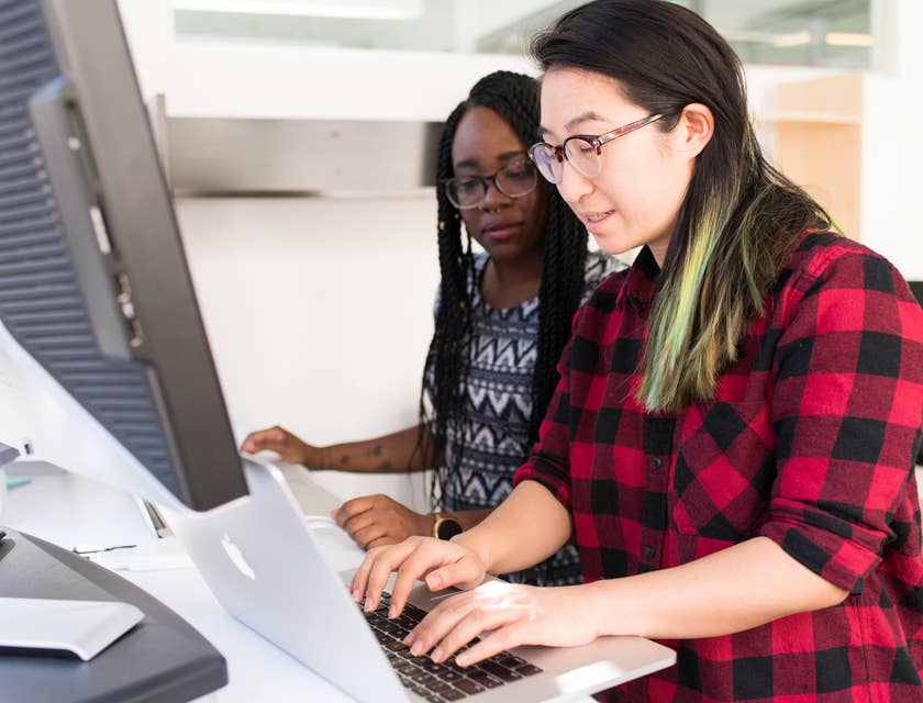 Female Head of Operations showing something on her laptop to her colleague