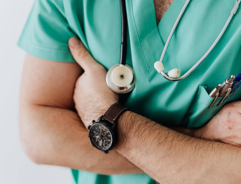 A doctor in scrubs with a statoscope and watch.
