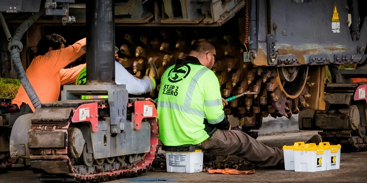 Heavy equipment mechanics doing repairs on a machine.