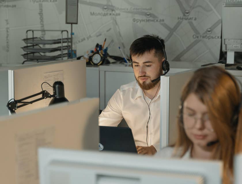 Help Desk Specialist talking to a client over the phone while sitting at his workstation