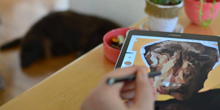A graphic designer drawing an electronic image of a dog in the top right corner.