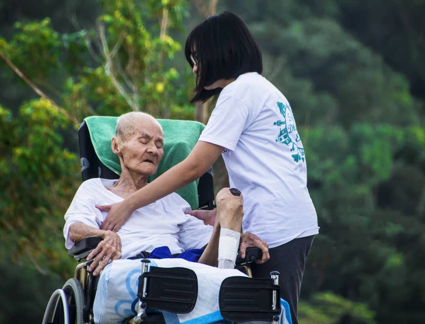 Home health aide positioning the patient to the wheelchair.