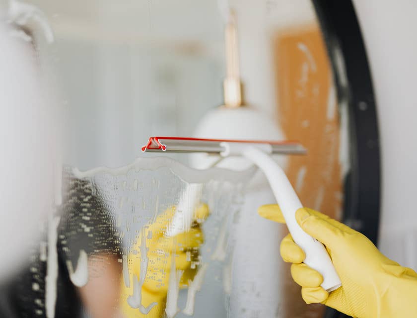 Homemaker cleaning a bathroom mirror