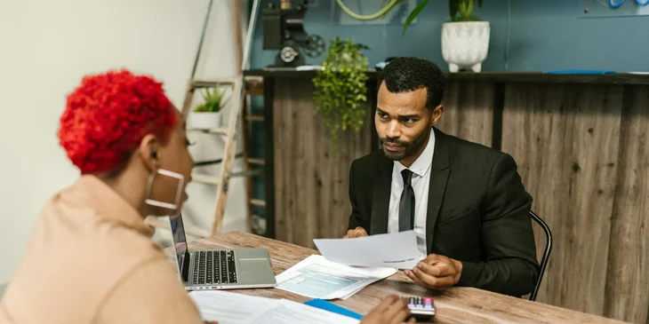 A health services administrator working on a budget plan with one of his staff.