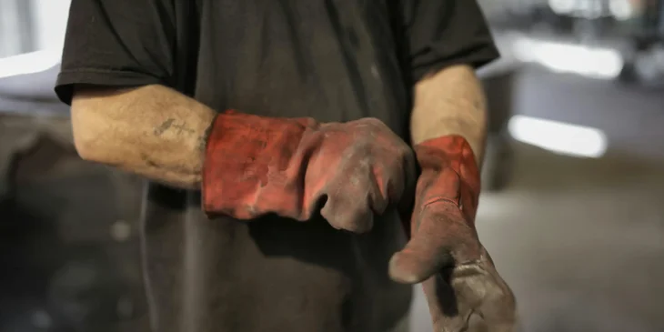 A laborer wearing heavy-duty gloves.