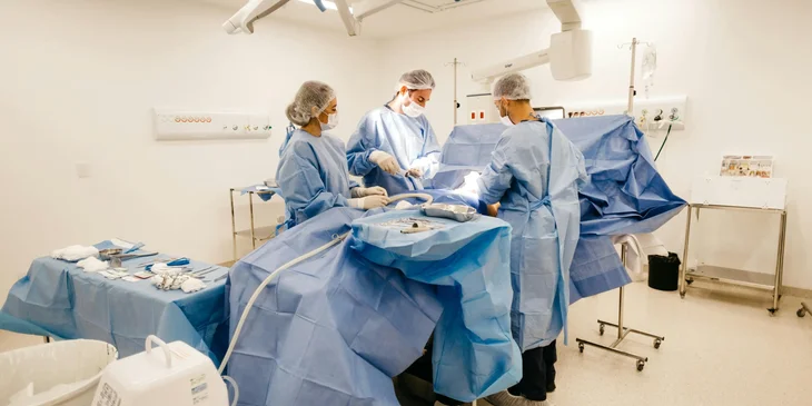 OR nurses assisting a surgeon in an operating room.