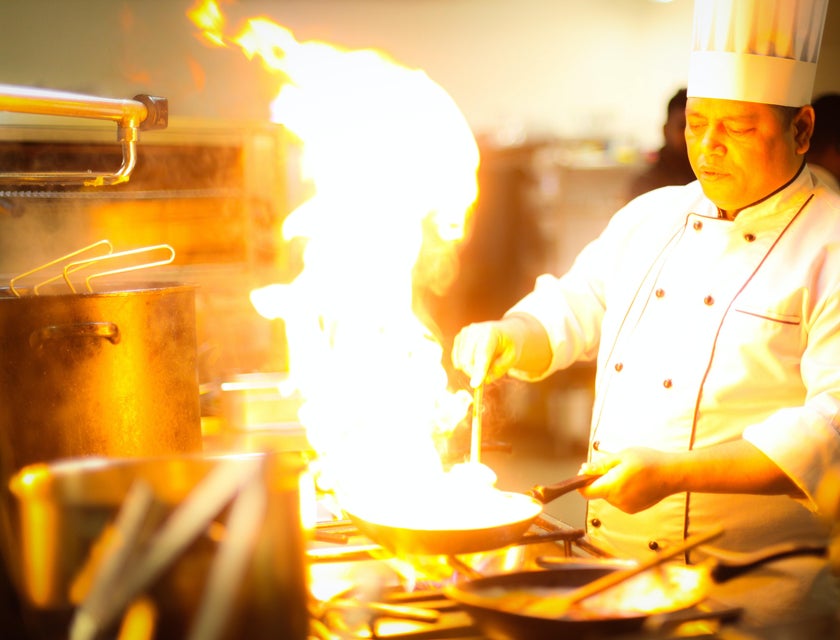 chef flambéing food in kitchen