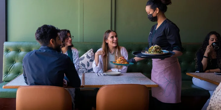 A waitress serving food to customers.