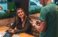 trabajador temporal tomando el pedido de una mujer en un restaurante