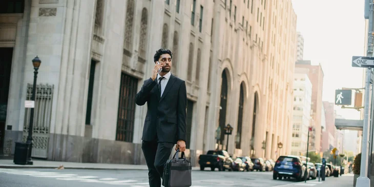A man crossing a pedestrian lane in the middle of the city.