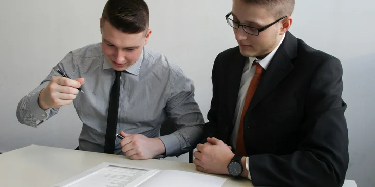 An HR coordinator issuing an employment contract to sign over.