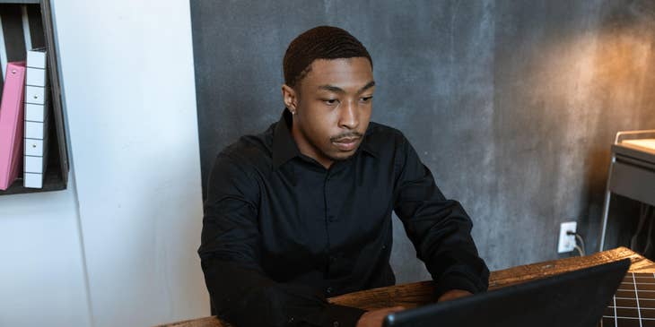 An HR representative working on his laptop and taking notes.