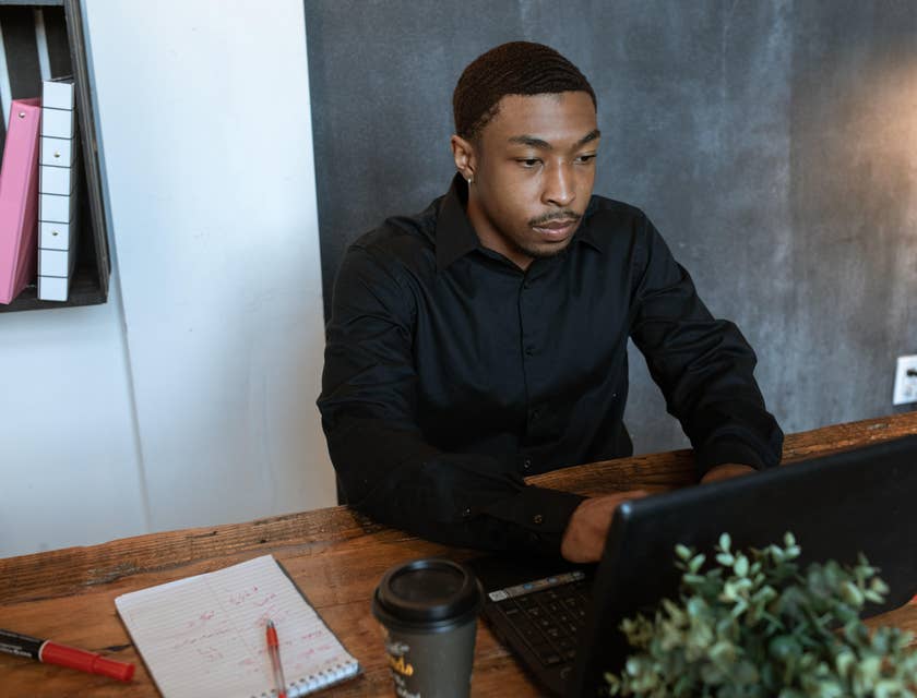 An HR representative working on his laptop and taking notes.