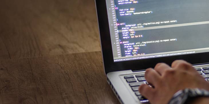 An HRIS Analyst on his laptop working on a software.