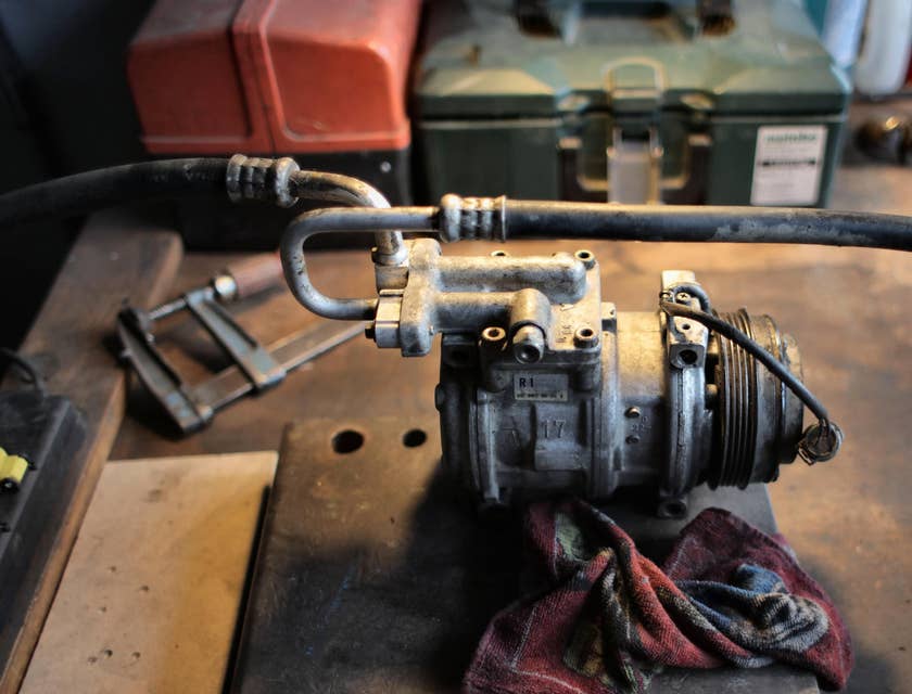 HVAC Technician repairing an airconditioner compressor in a workbench