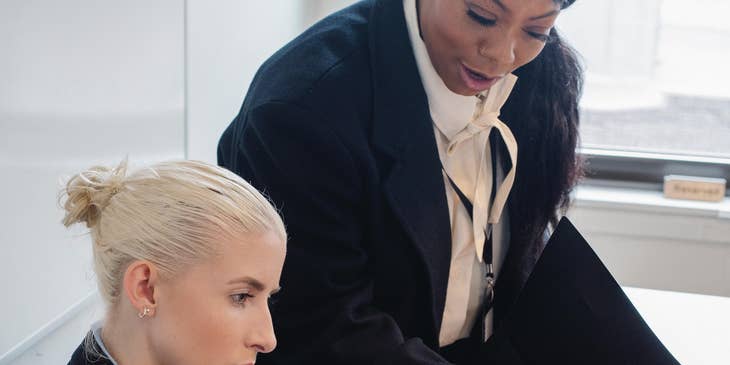 A Female Immigration Paralegal reporting and presenting visa petition document to an Immigration Program Manager.