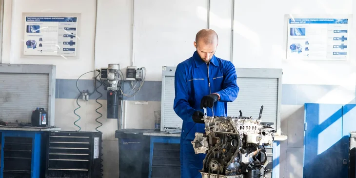 An industrial maintenance mechanic repairing an engine.