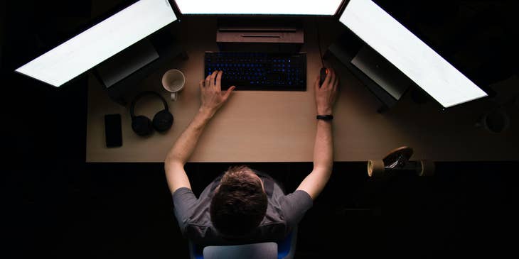 Infrastructure Engineer working on his three monitors and building a system of supported networks for the company