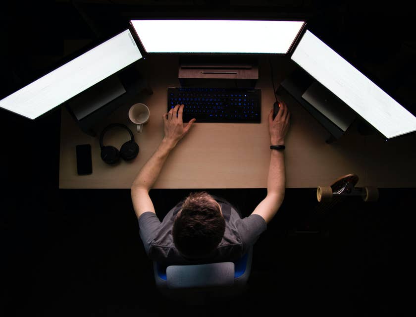 Infrastructure Engineer working on his three monitors and building a system of supported networks for the company
