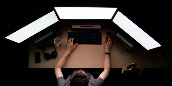 Infrastructure Engineer working on his three monitors and building a system of supported networks for the company