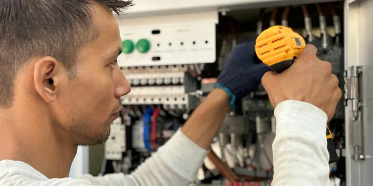An installation technician working on an electrical panel.