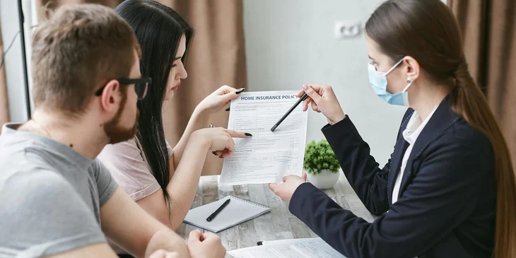 An insurance agent explaining a document to a couple.