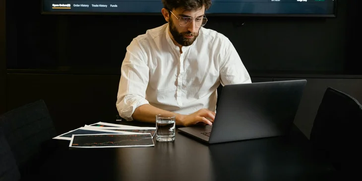 An intelligence analyst reading a classified report on his laptop.