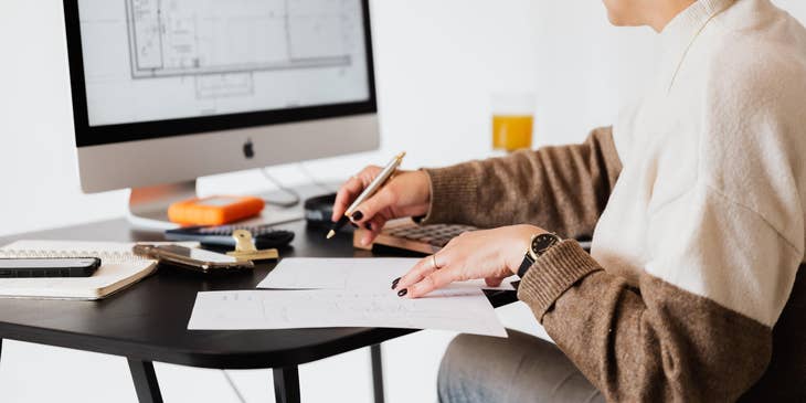 Interior Designer sketching new design plans while comparing on her computer
