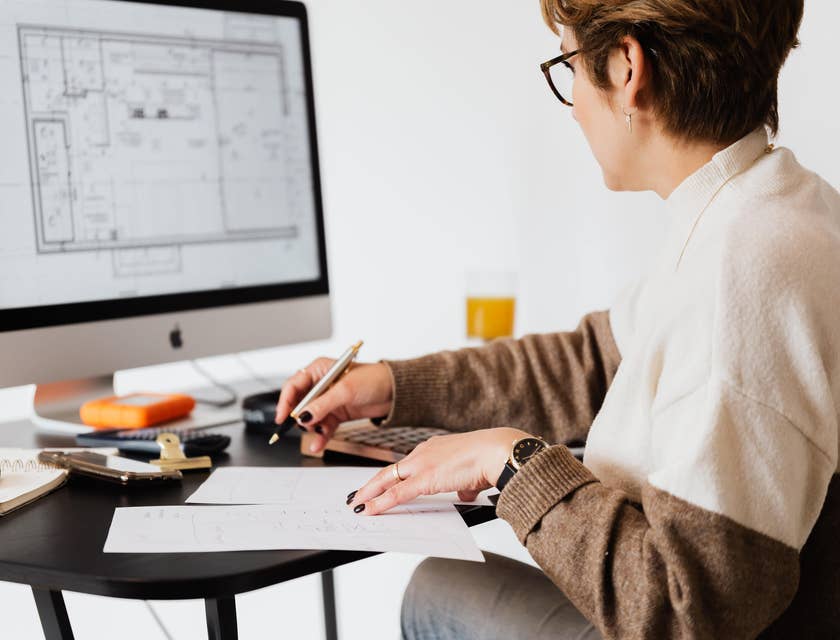 Interior Designer sketching new design plans while comparing on her computer